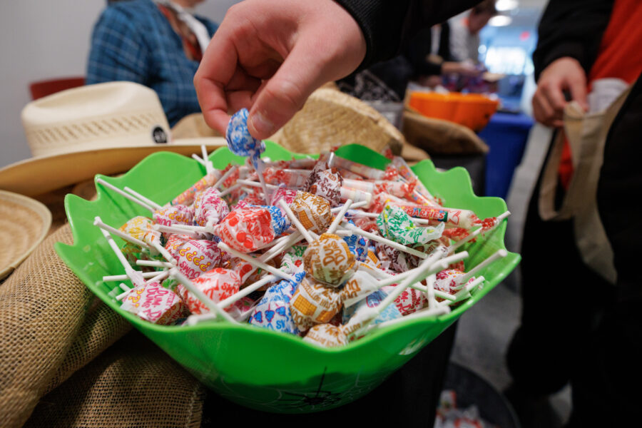 A guest reaches for a piece of candy in a bowl while trick or treating at MMI.