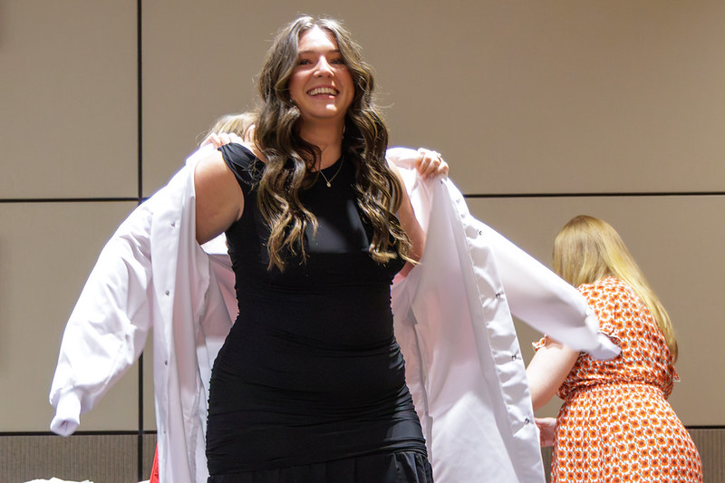 A new UNMC College of Dentistry student dons her white coat.