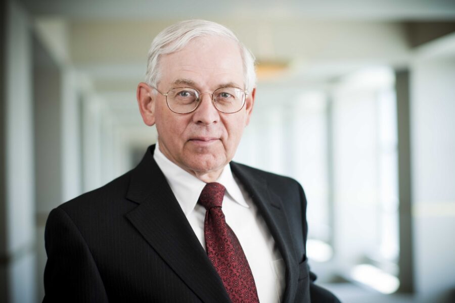 Don Leuenberger, in the Sorrell atrium, wearing a dark suitcoat, white shirt and red tie