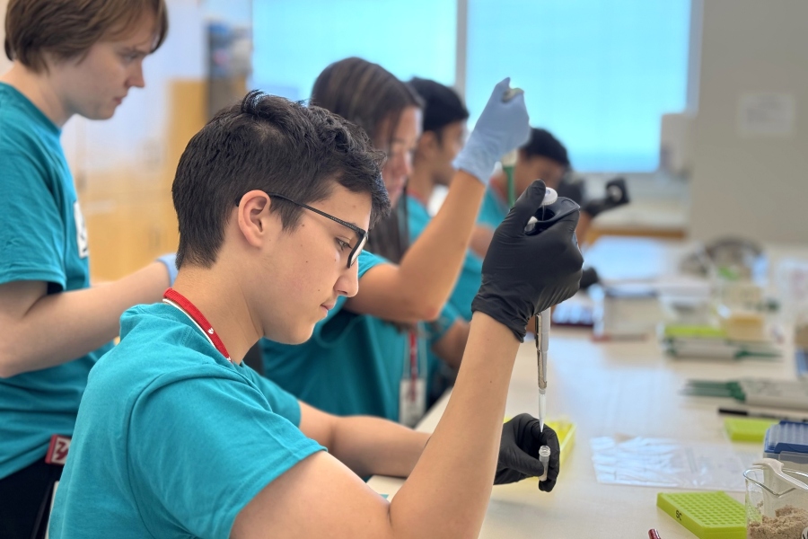 Teen boy and others learn how to work in laboratory