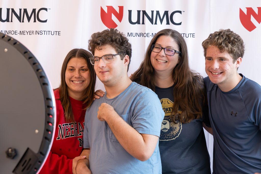 Four family members pose in a photo booth set up at the Munroe-Meyer Institute.
