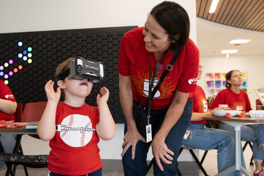 A young visitor tries out a virtual reality headset in the Munroe-Meyer Institute lobby during the High 5 event&period;