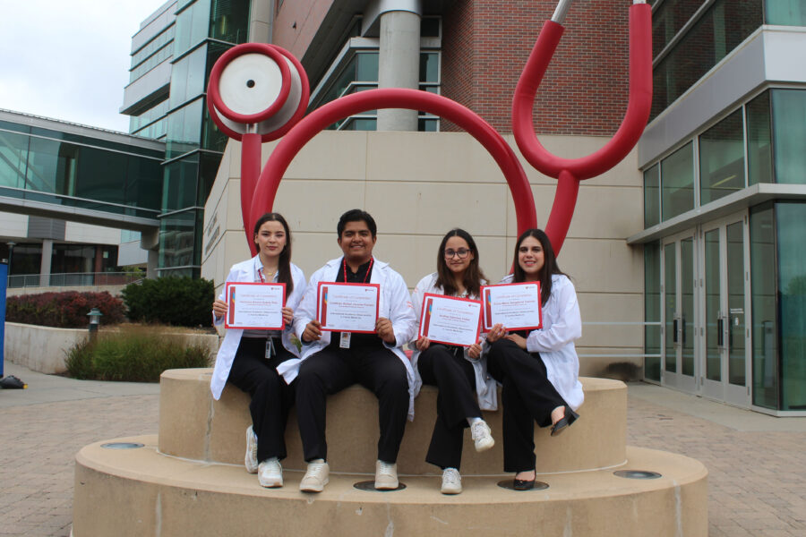 From left&comma; UAV students Ver&oacute;nica Dinora Duarte Ru&iacute;z&comma; Cristhian Rafael J&aacute;come Parada&comma; Andrea S&aacute;nchez Y&aacute;&ntilde;ez and Dulce Mar&iacute;a Sangabriel Galindo pose at the stethoscope sculpture in front of the Sorrell Center in Omaha&period;