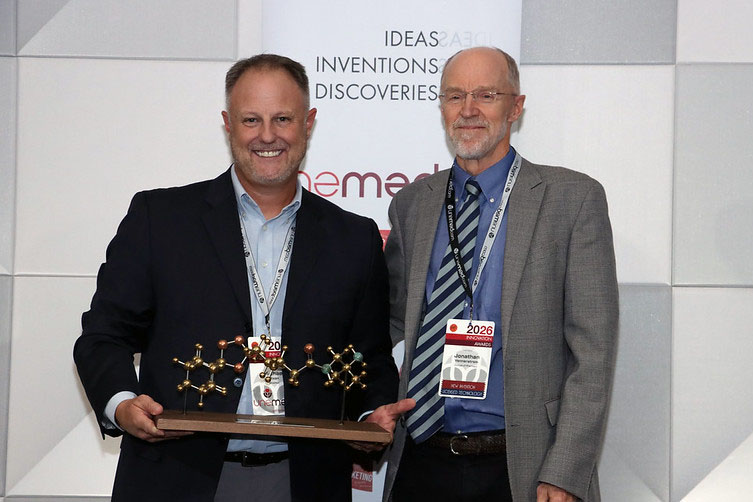 UNeMed CEO Michael Dixon&comma; PhD&comma; gives Jonathan Vennterstrom&comma; PhD&comma; a gift Dr&period; Dixon called a "Lifetime Achievement Award" at the event&period;