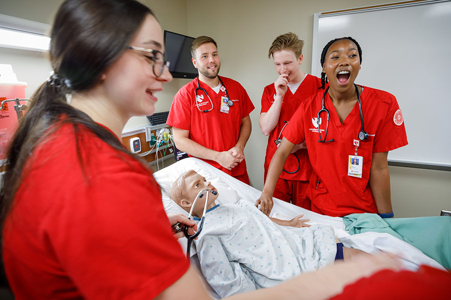 BSN nursing students interact with a faculty member.