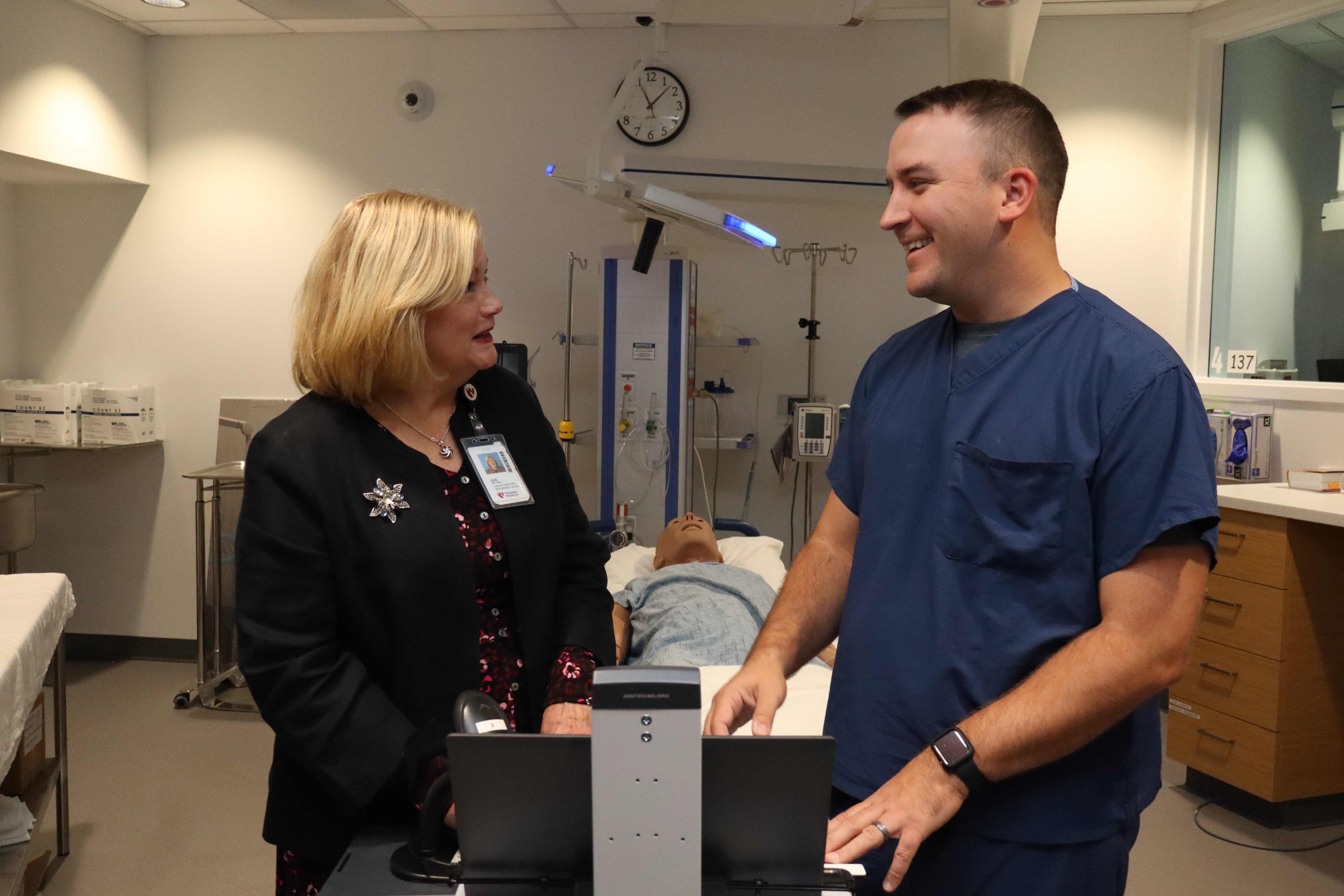 a woman talks with a student in a simulation setting