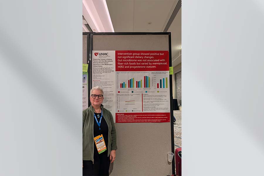 Dr. Lally standing beside her poster.