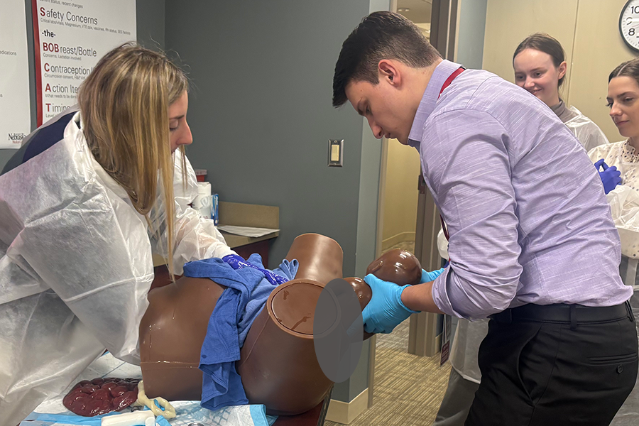 Third-year medical student delivers a baby during a simulation with Dr. Carly Jennings