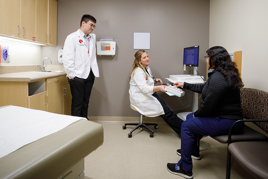 Simulated patient in the Olson Center with student and doctor.