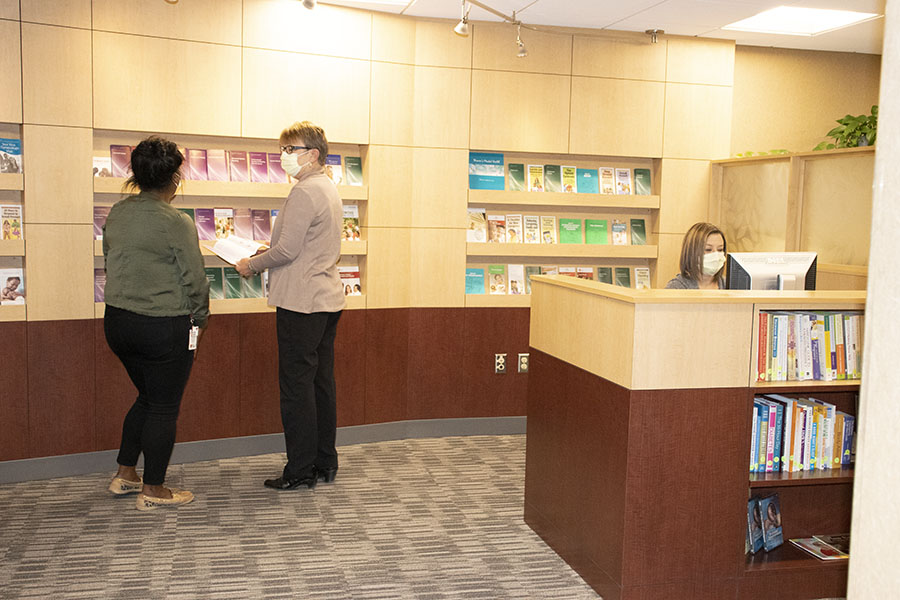 Resource center employee and two patients accessing resources