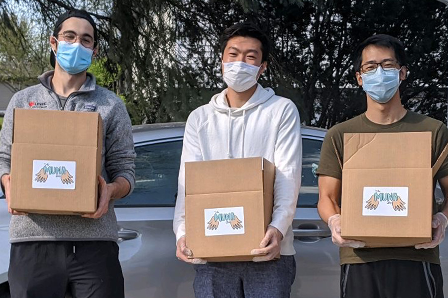 Students stand and hold care boxes filled with staples and toiletries