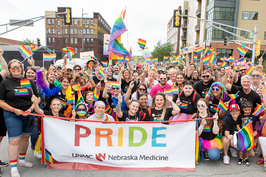 Employees walk in the Pride Parade carrying a banner