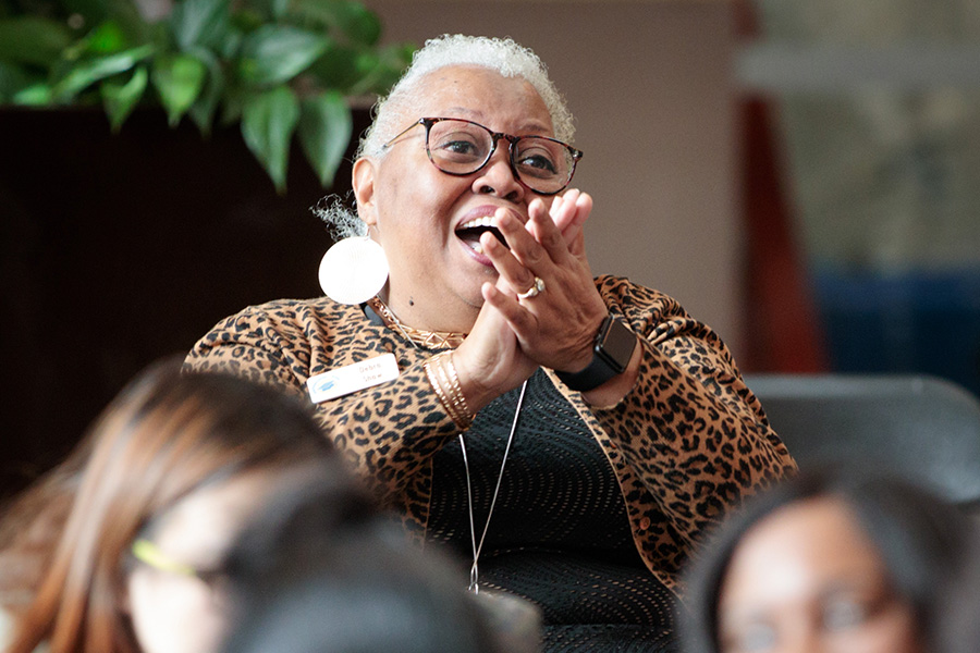 Woman claps and smiles at event