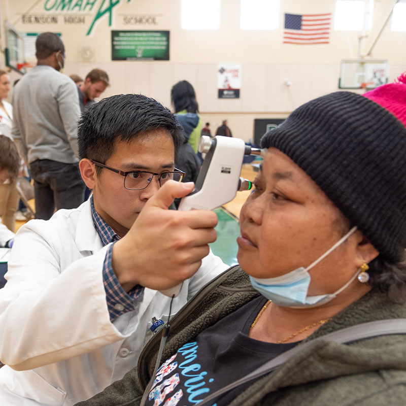 Student examines a person at a health fair