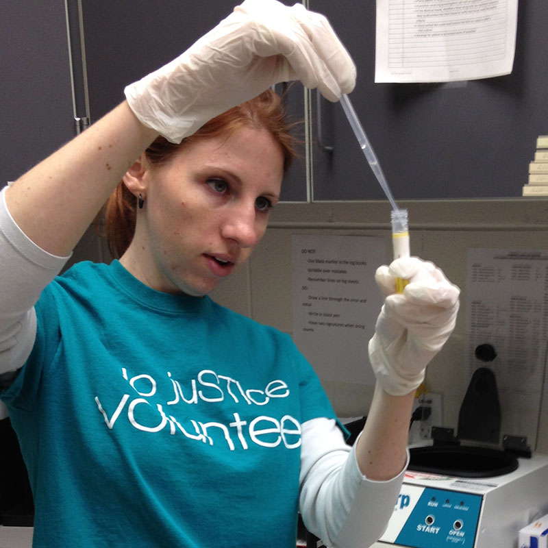 Student examines urine in test tube for STI test