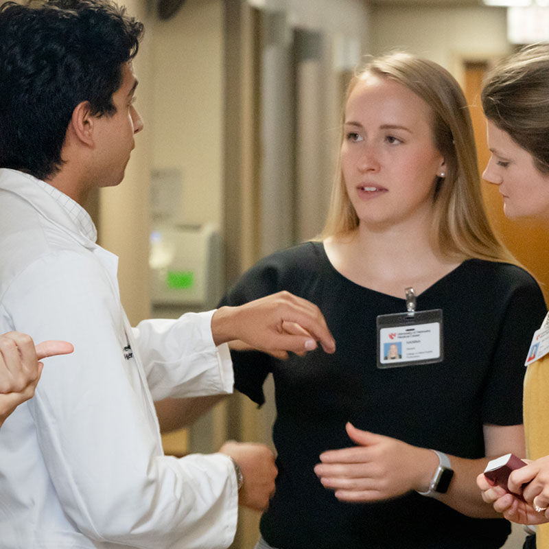 Faculty member gives advice to students working in the clinic