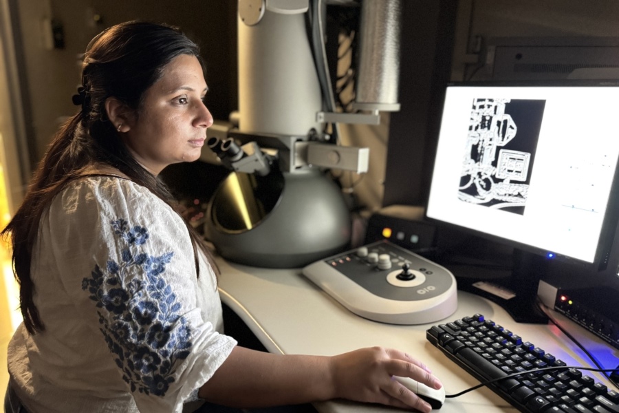 Woman sitting at computer in darkened laboratory