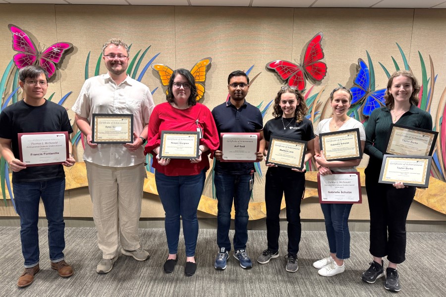 Seven graduate students holding awards