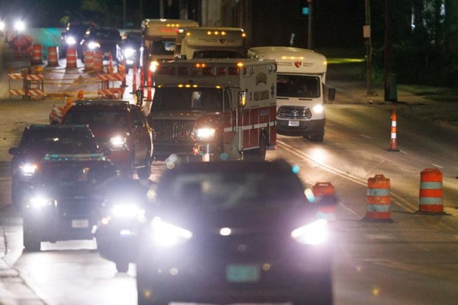 An ambulance and shuttle buses driving in the dark