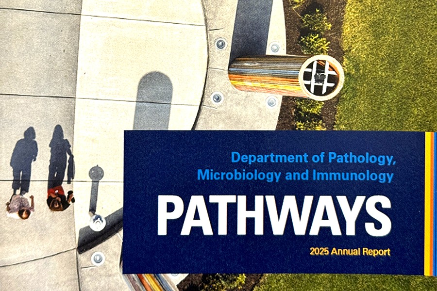 2025 annual report cover has aerial photo of two people walking on UNMC campus