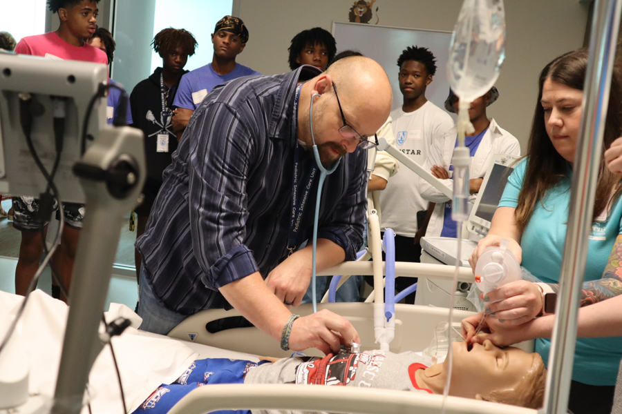 physician looks in on training medical dummy