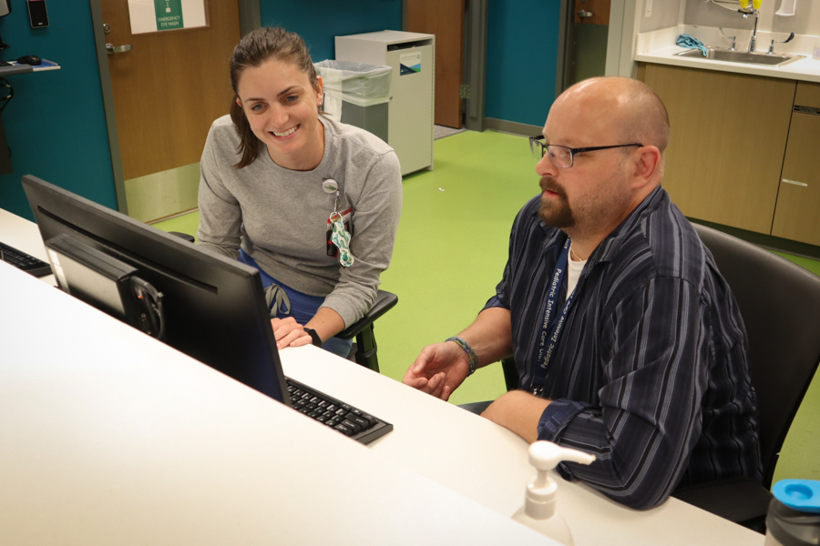 female fellow and male fellowship director look at computer screen