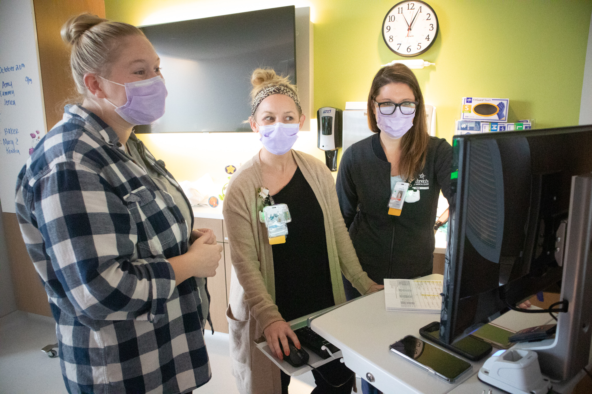doctors looking at computer screen with mom of patient