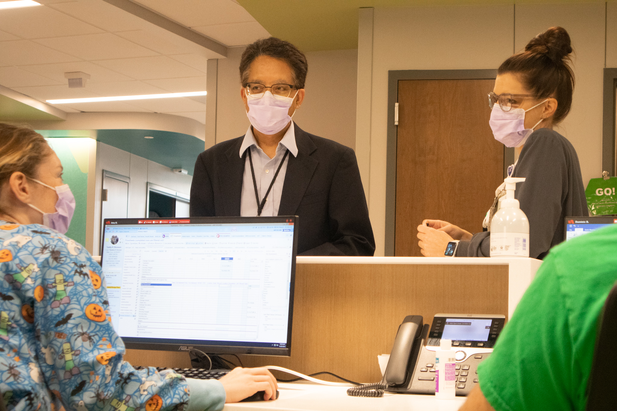 three people talking at hospital desk