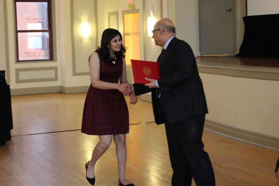 Fellow receiving diploma from faculty member