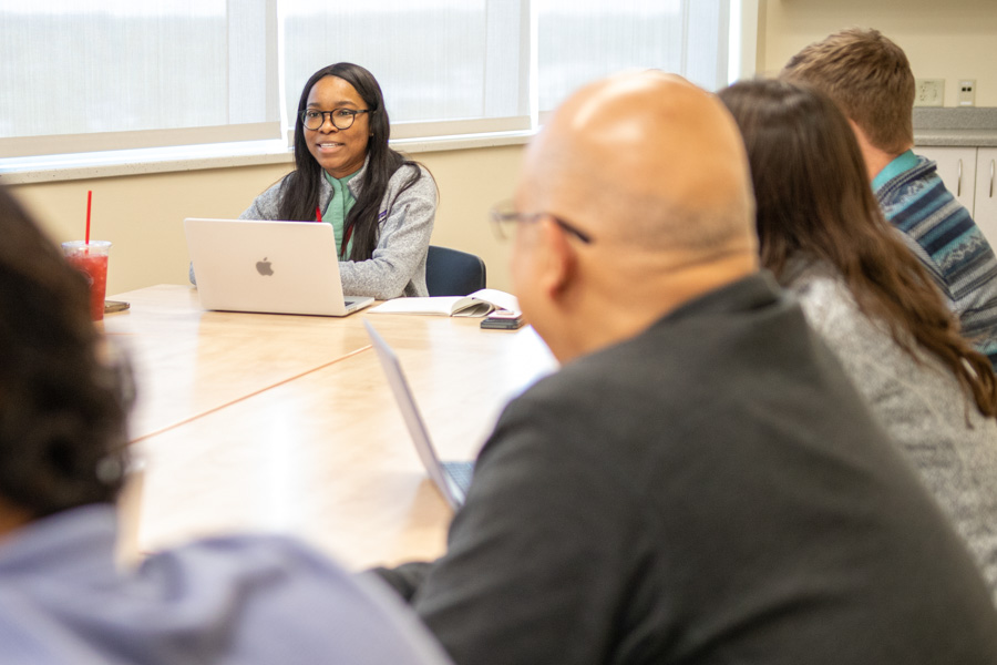 fellow presents her research project to table of peers
