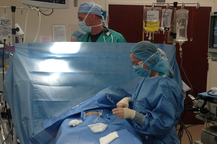 two people in scrubs in a operating room 