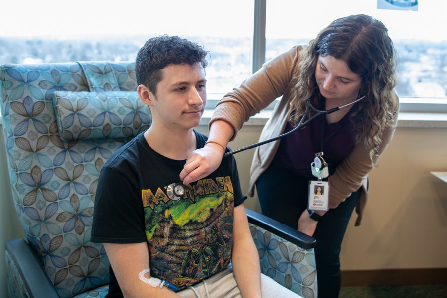 doctor listening to patients heart through stethoscope
