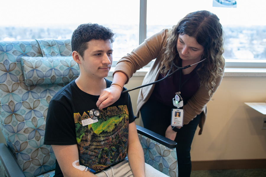 doctor listening to patients heart through stethoscope
