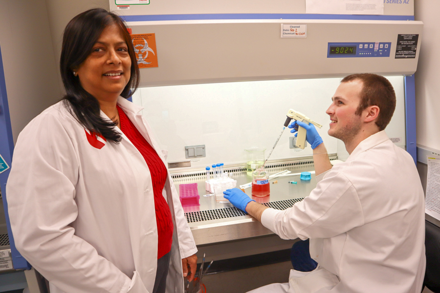 woman lab working looking at camera, man lab worker looks at her