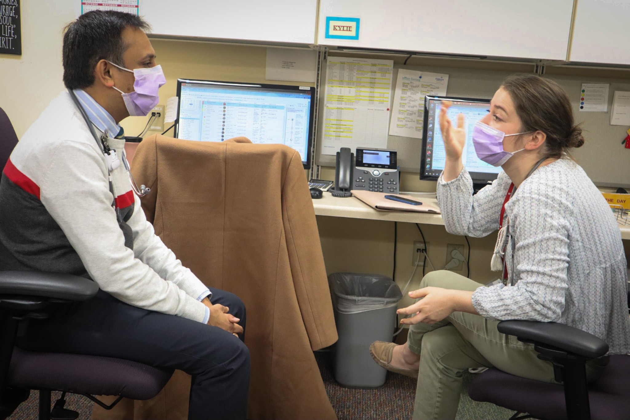 two doctors talk to one another in medical clinic
