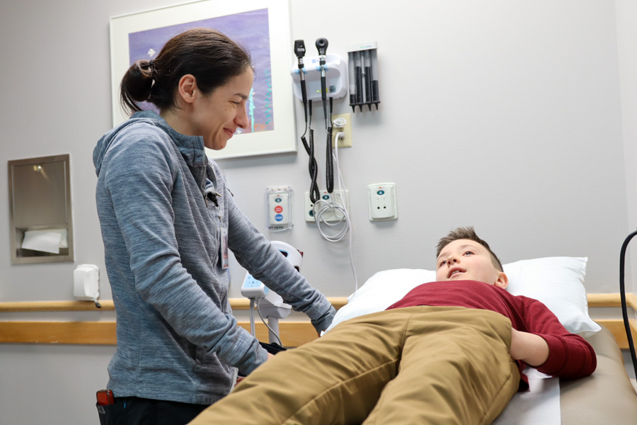 Doctor talking and looking down to a patient in bed