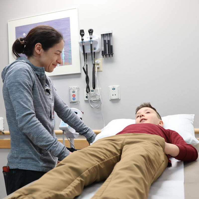 doctor talking to patient laying on bed