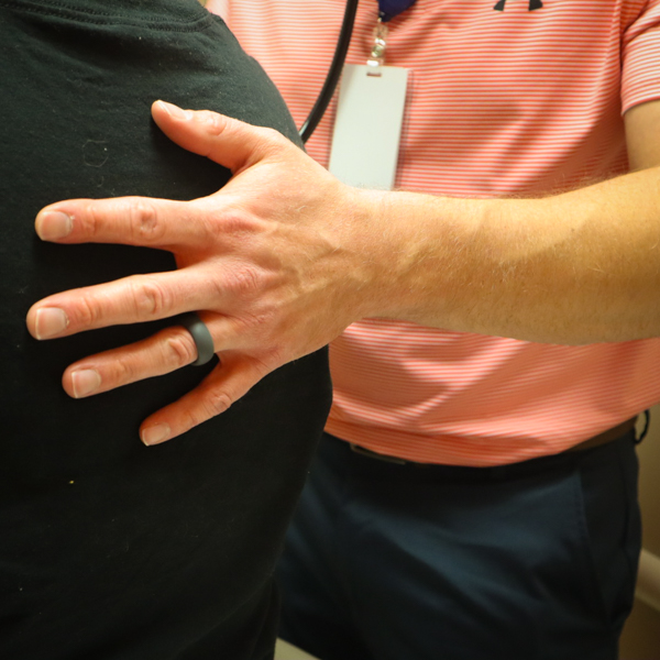 doctors's hand on the back of a patient