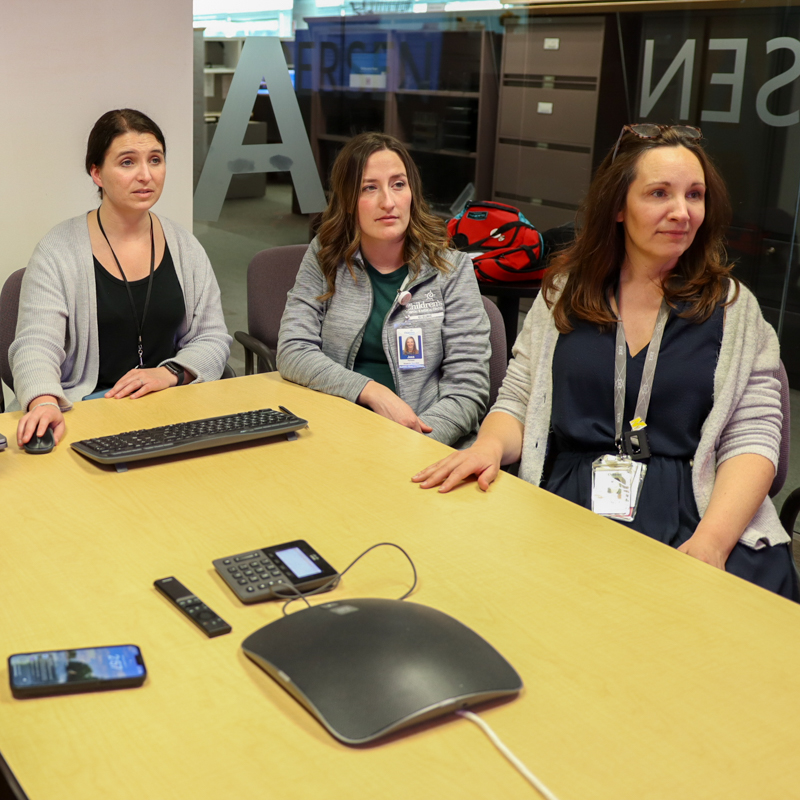 genetics doctors sitting around table looking up at computer screen