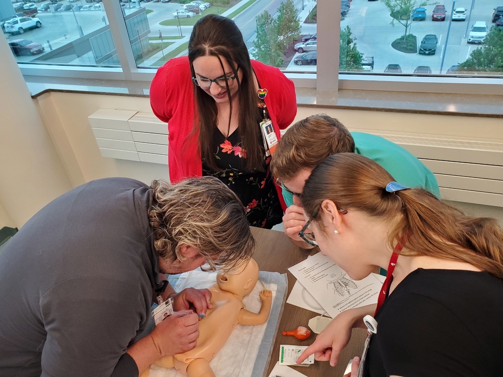 Doctors examine a teaching model of a baby