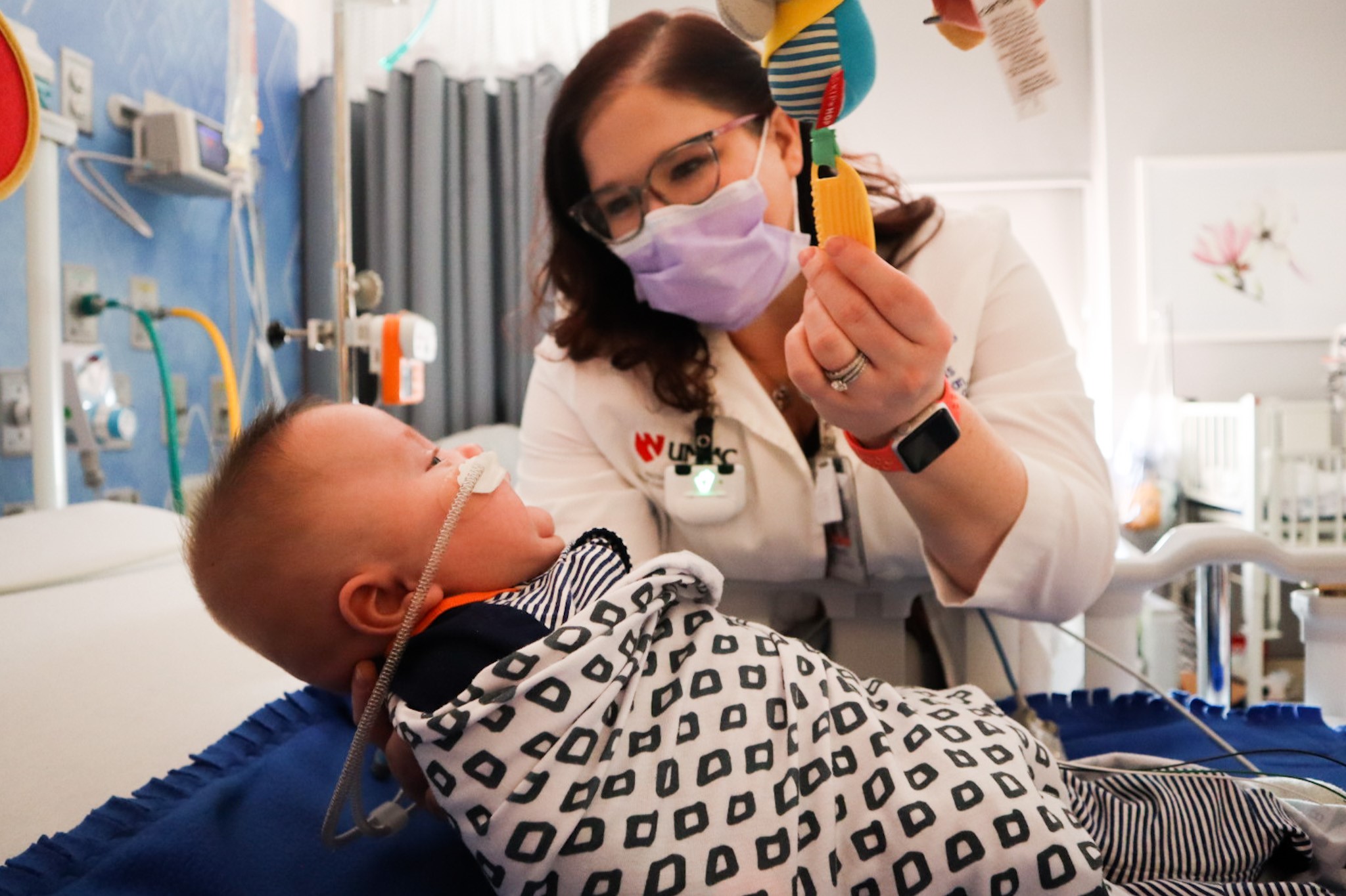 doctor holds baby wrapped in a blanket