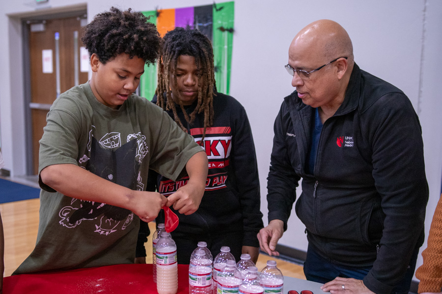 doctor working with children on an experiment at NorthStar Family Night event