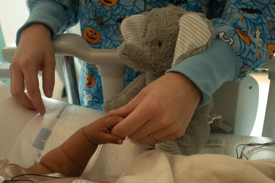 baby in hospital holding adult's hand