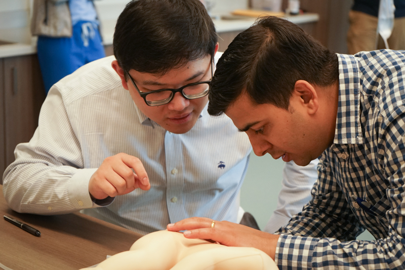 Students examining mannequin baby