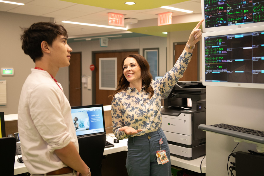 a doctor explains something on a monitor to a student