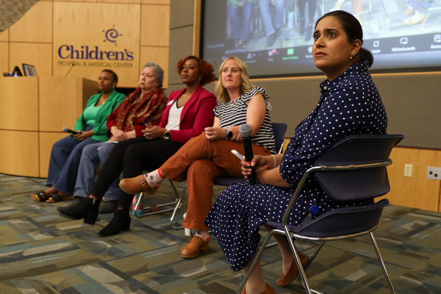 Women in dais at event look up and to the right