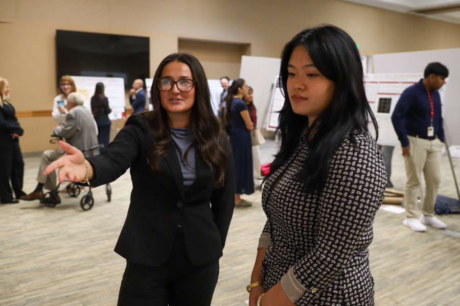 two trainee researchers talk about poster