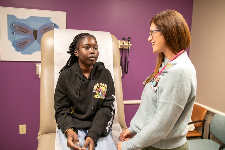 doctor talks to a patient sitting on exam table