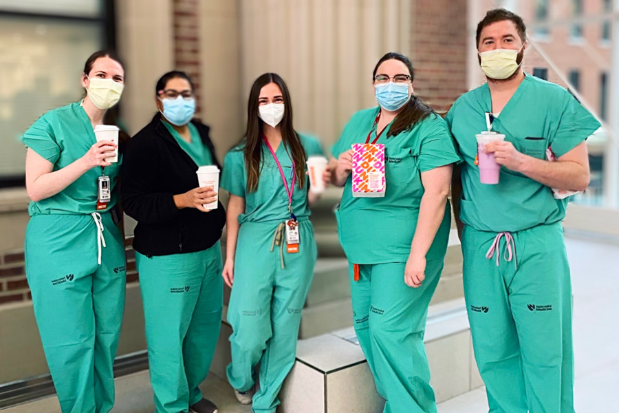 Residents wearing scrubs holding coffee cups