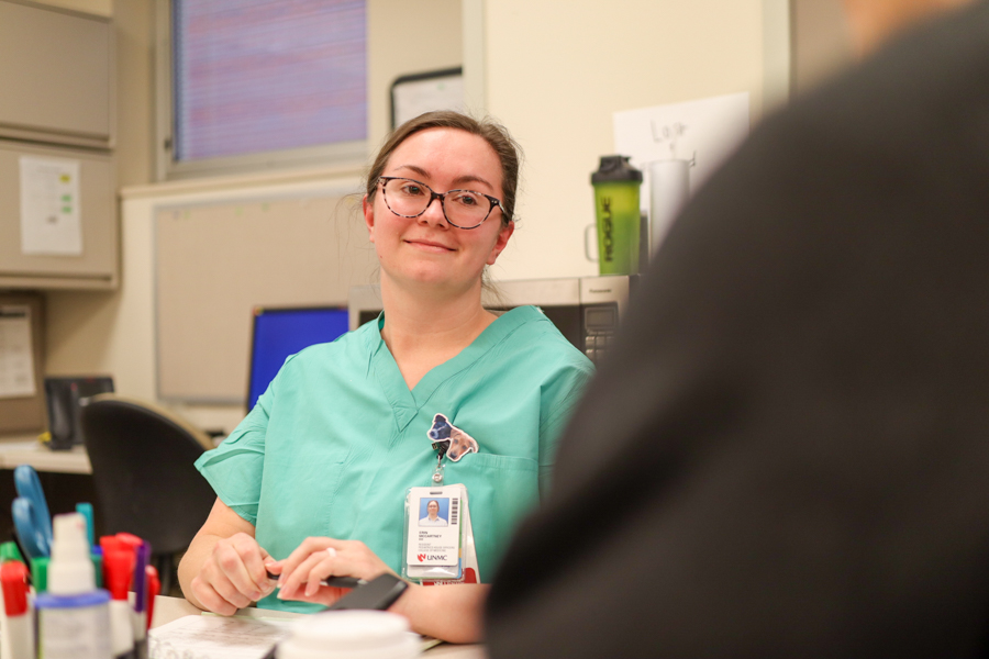 resident sitting at a table in scrubs